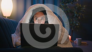 Hispanic freelancer girl Latino woman Indian Arabian female at night evening home at couch sofa under blanket cover