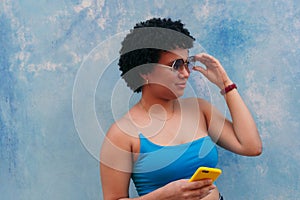 Hispanic girl with a blue blouse in front of a blue background