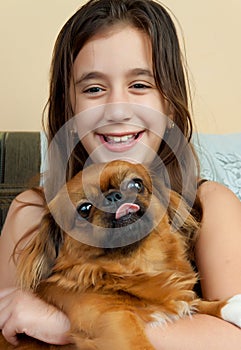 Hispanic girl carrying her small pekingese dog