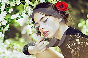 Hispanic girl with fashionable spanish makeup, rose flower in hair. Beautiful Young Woman with Clean Fresh Skin.