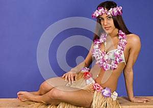 Hispanic girl in a flower lay and grass skirt