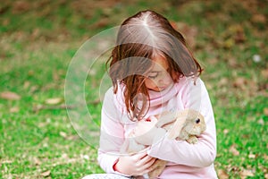 Hispanic girl with a rabbit in the park