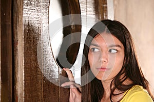 Hispanic girl sneeking a look in window