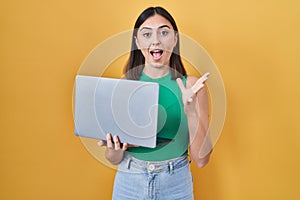 Hispanic girl working using computer laptop celebrating victory with happy smile and winner expression with raised hands