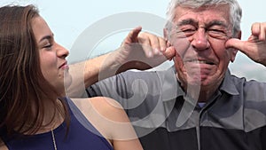 Hispanic grandfather and granddaughter funny faces