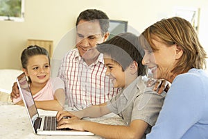 Hispanic Grandparents And Grandchildren Using Computer At Home