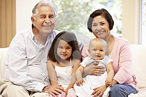 Hispanic grandparents at home with grandchildren photo