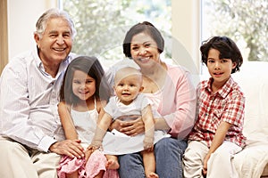 Hispanic grandparents at home with grandchildren