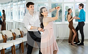 Hispanic guy enjoying merengue with young female partner in dance class