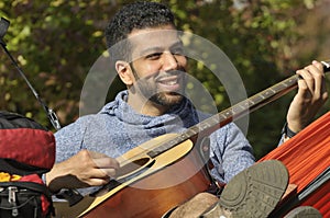Hispanic Guy Playing Guitar ina Hammock