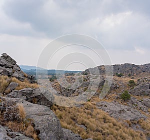 A Hispanic hiker on top of mount Tlaloc under a cloudy sky in Mexico