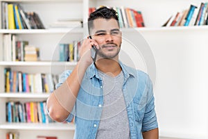 Hispanic hipster man in quarantine talking at mobile phone