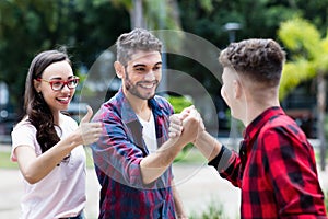 Hispanic hipster young adult giving highfive to friend