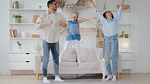 Hispanic Indian Caucasian multiethnic multiracial family dancing at home. Mother father parents move to music with girl