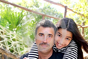 Hispanic latin father and teen daughter hug park