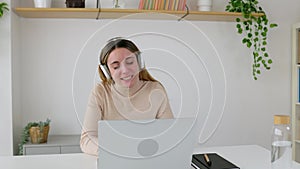 Hispanic latin pretty young adult woman having a video call on laptop at home