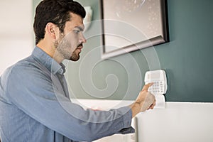 Hispanic man arming his alarm system