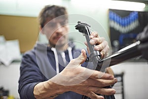 Hispanic man assembling a bicycle in his bike shop during maintenance service