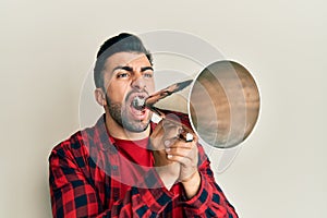 Hispanic man with beard screaming with vintage megaphone