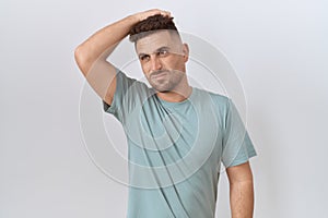 Hispanic man with beard standing over white background confuse and wondering about question