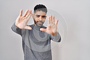 Hispanic man with beard standing over white background doing frame using hands palms and fingers, camera perspective
