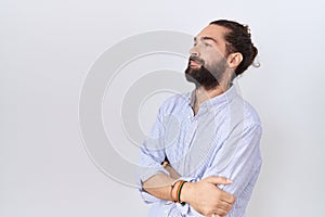 Hispanic man with beard wearing casual shirt looking to the side with arms crossed convinced and confident