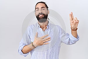 Hispanic man with beard wearing casual shirt smiling swearing with hand on chest and fingers up, making a loyalty promise oath