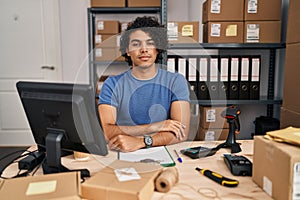 Hispanic man with curly hair working at small business ecommerce looking sleepy and tired, exhausted for fatigue and hangover,