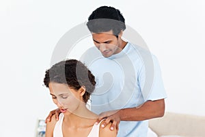 Hispanic man doing a massage to his beautiful wife