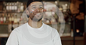 Hispanic man football fan with painted face cheering for favorite team at pub