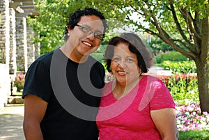 Hispanic man and his mother smiling outdoors