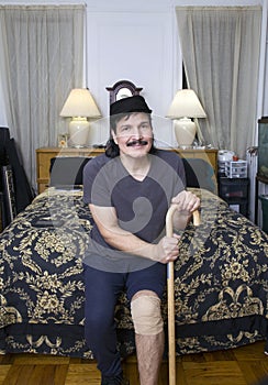 Hispanic man with knee bandage and cane on bed with smile