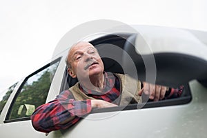 Hispanic man looking out of car being sad and irritated because of traffic jams