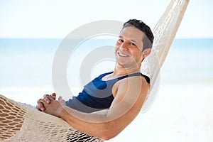 Hispanic man relaxing in a hammock at the beach