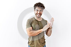 Hispanic man standing over isolated white background clapping and applauding happy and joyful, smiling proud hands together