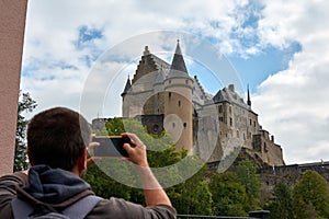 Hispanic man taking photos of Vianden Castle in Luxembourg