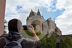 Hispanic man taking photos of Vianden Castle in Luxembourg