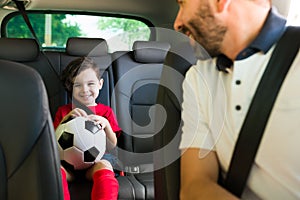 Hispanic man talking with his son in the car