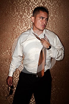 Hispanic man tugging on his tie