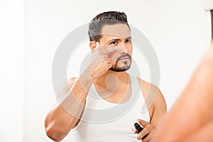 Hispanic man using an under eye cream