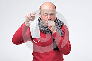 Hispanic mature man having flu and cough.