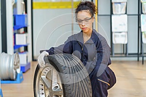 hispanic mechanic woman worker checking car tires in auto repair shop store service. latin female worker maintenance examining