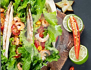 Hispanic mexican food, meat tacos with shrimps on dark background