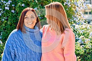 Hispanic mother and daughter smiling happy and hugging at the park