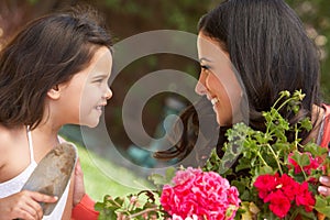 Hispanic Mother And Daughter Working In Garden Tidying Pots photo