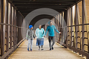 Hispanic Mother Walks With Sons On A Bridge