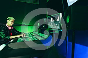 Hispanic music producer mixing new music album inside boutique studio - Main focus on woman hands