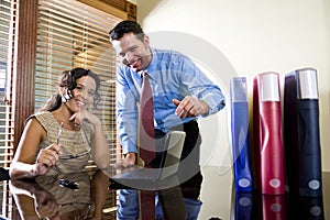 Hispanic office worker working with male colleague