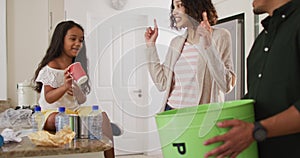 Hispanic parents and daughter teaching segregating paper trash