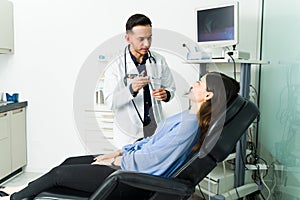 Hispanic physician talking with a young woman photo